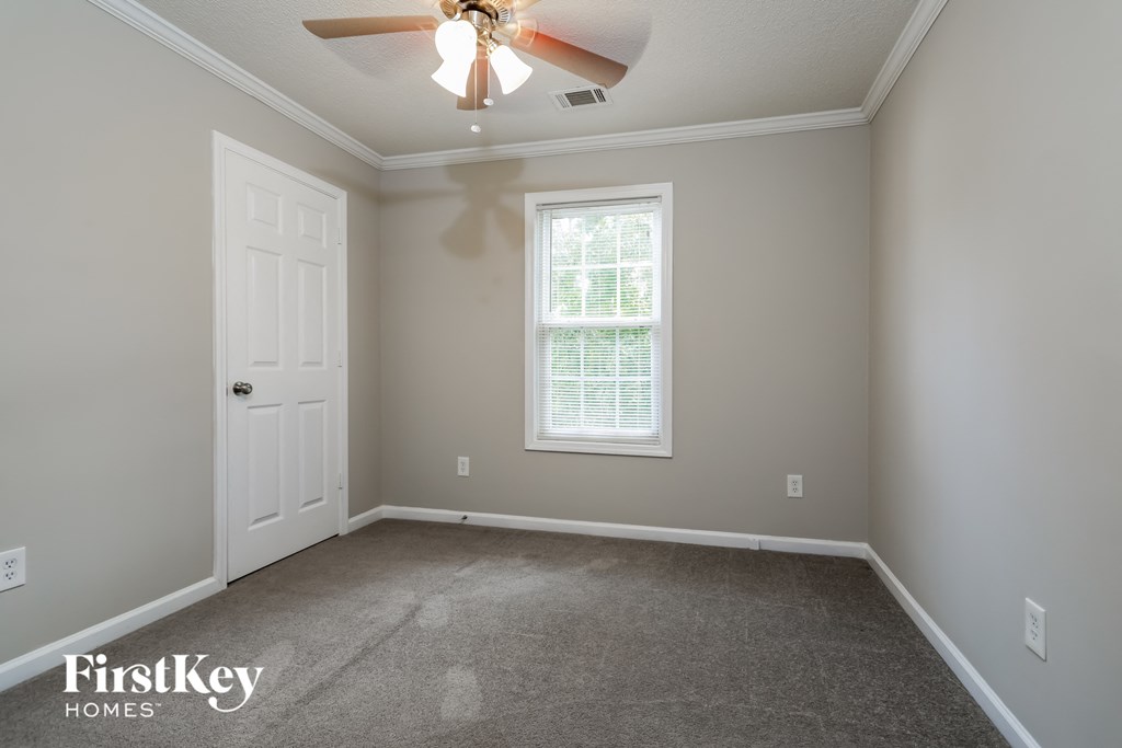 a bedroom with a ceiling fan and a white door