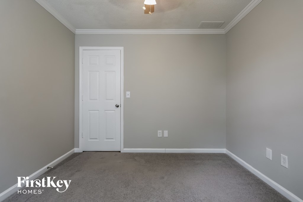a bedroom with a white door and a carpeted floor