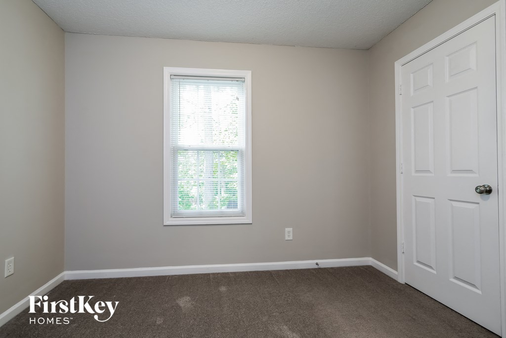 a bedroom with a white door and a window
