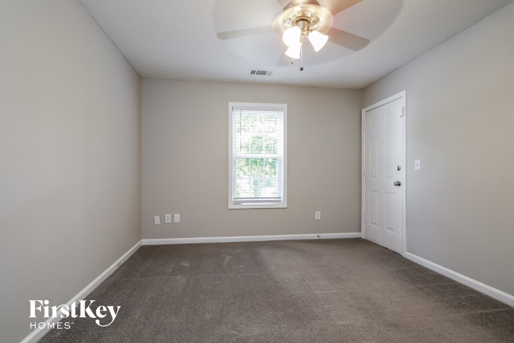 a bedroom with a carpeted floor and a ceiling fan
