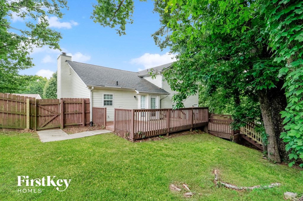 a backyard with a fence and a white house