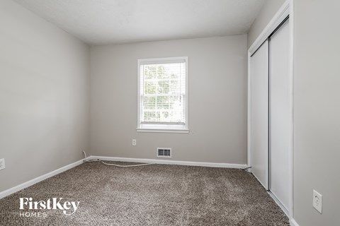 a bedroom with a carpeted floor and a window
