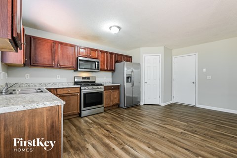 A kitchen with wooden cabinets and a refrigerator.