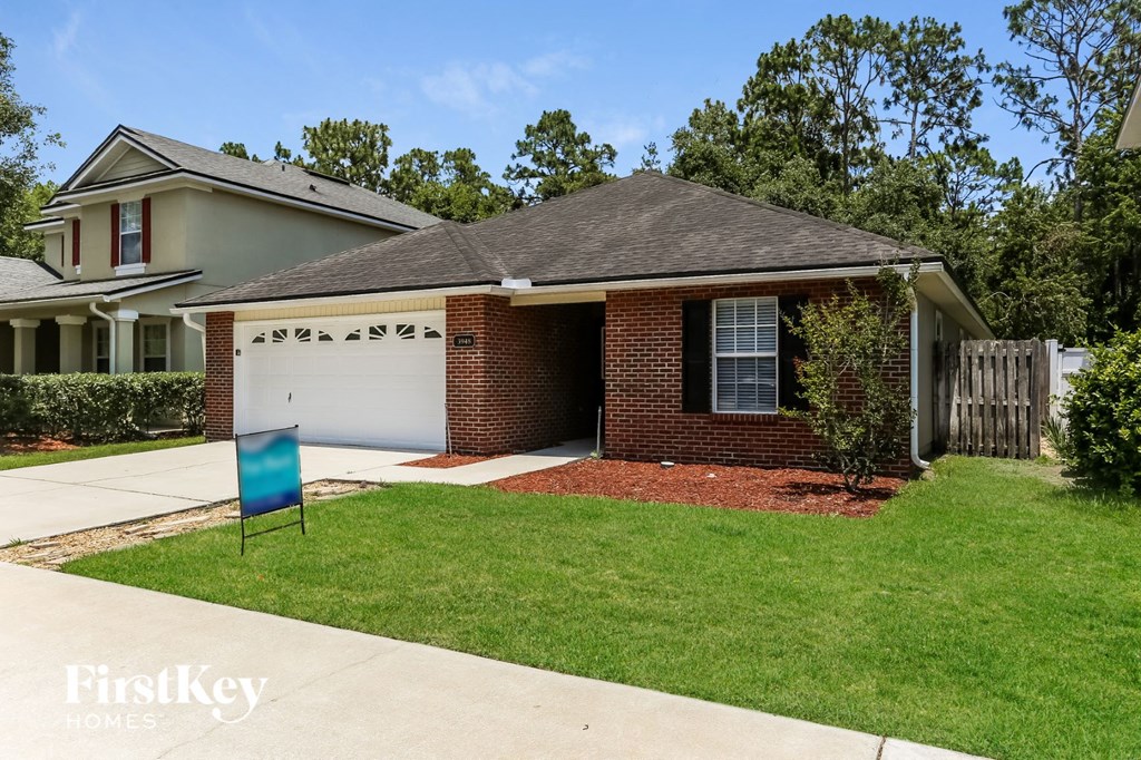 a small brick house with a white garage door