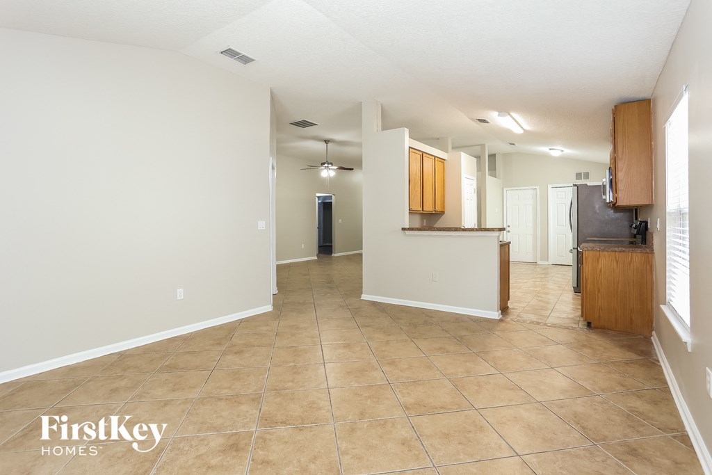an empty kitchen and living room with tile flooring