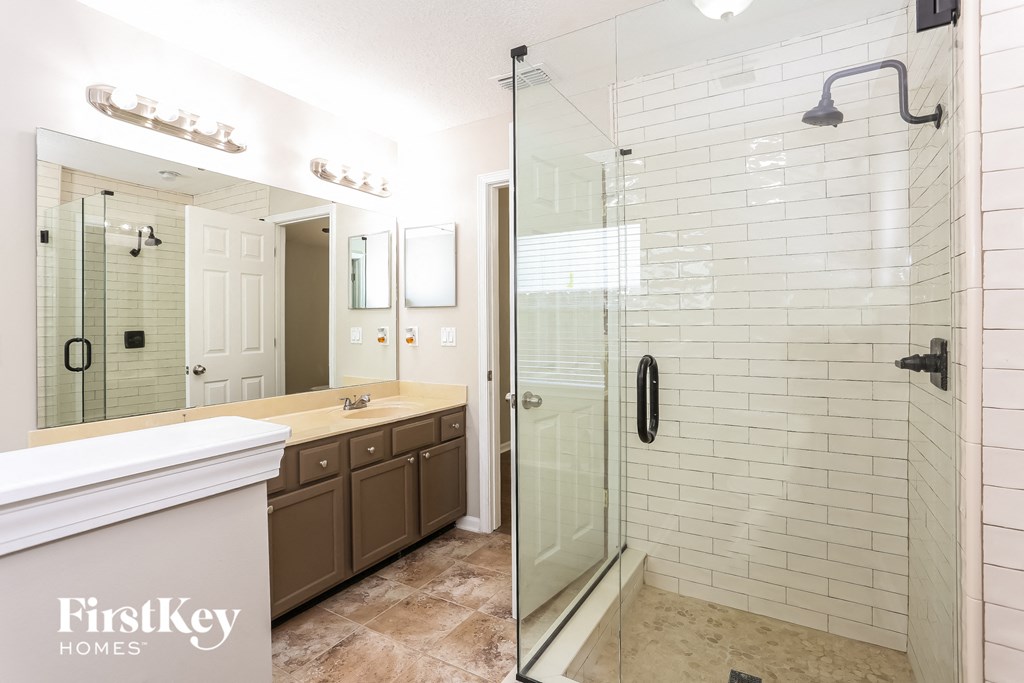 a bathroom with a shower and a sink and a mirror