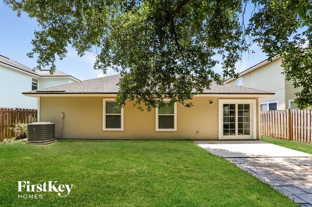 a small yellow house with a lawn and a driveway