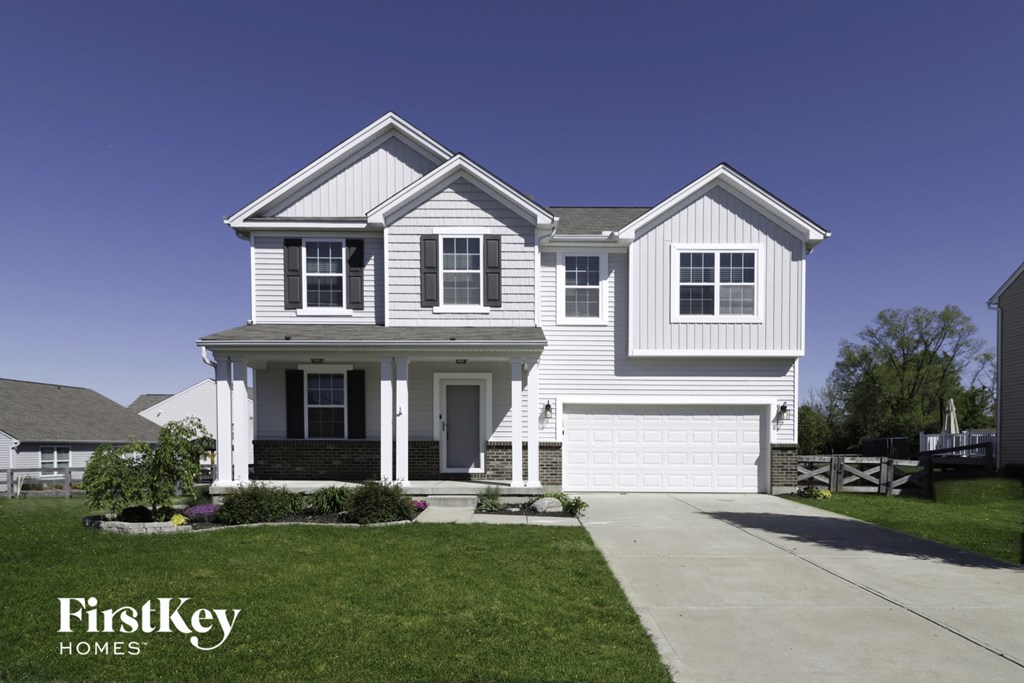 a white house with white siding and a driveway