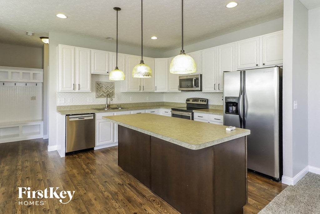 a kitchen with white cabinets and stainless steel appliances