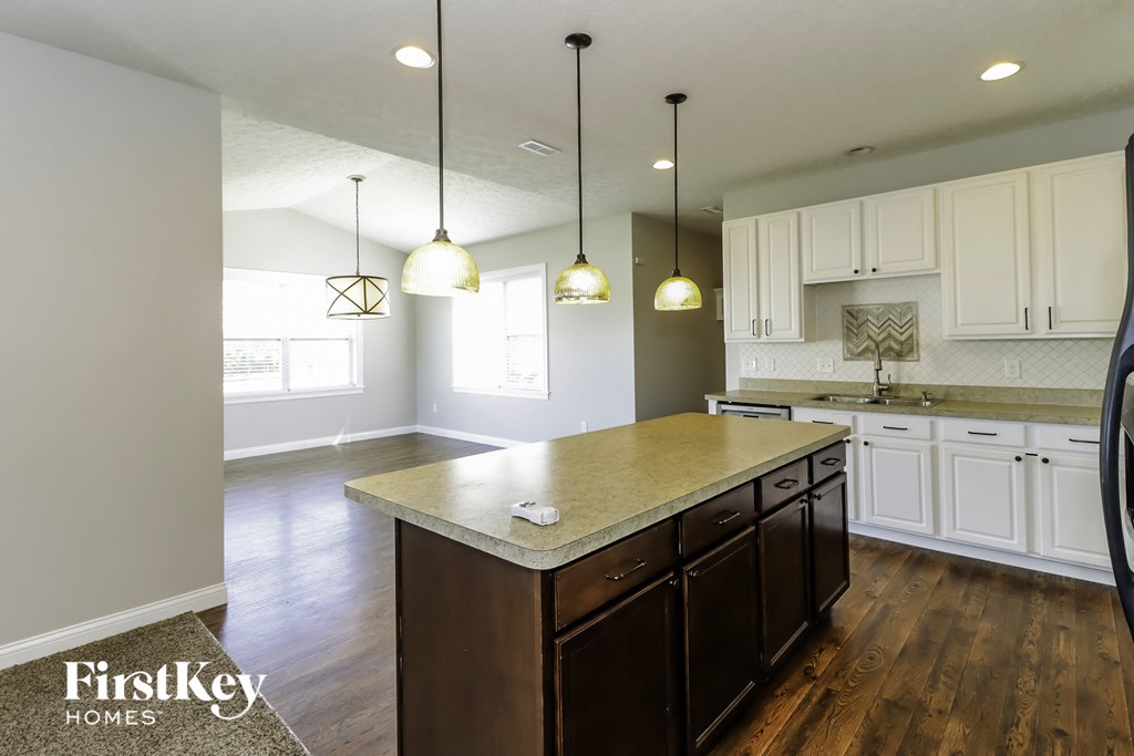 a kitchen with white cabinets and a marble counter top