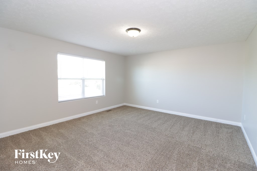 an empty room with carpet and a window