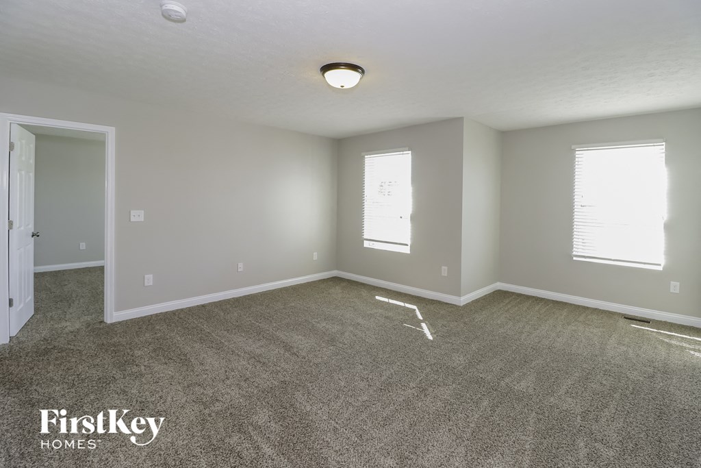 the living room of an empty house with carpet and a door