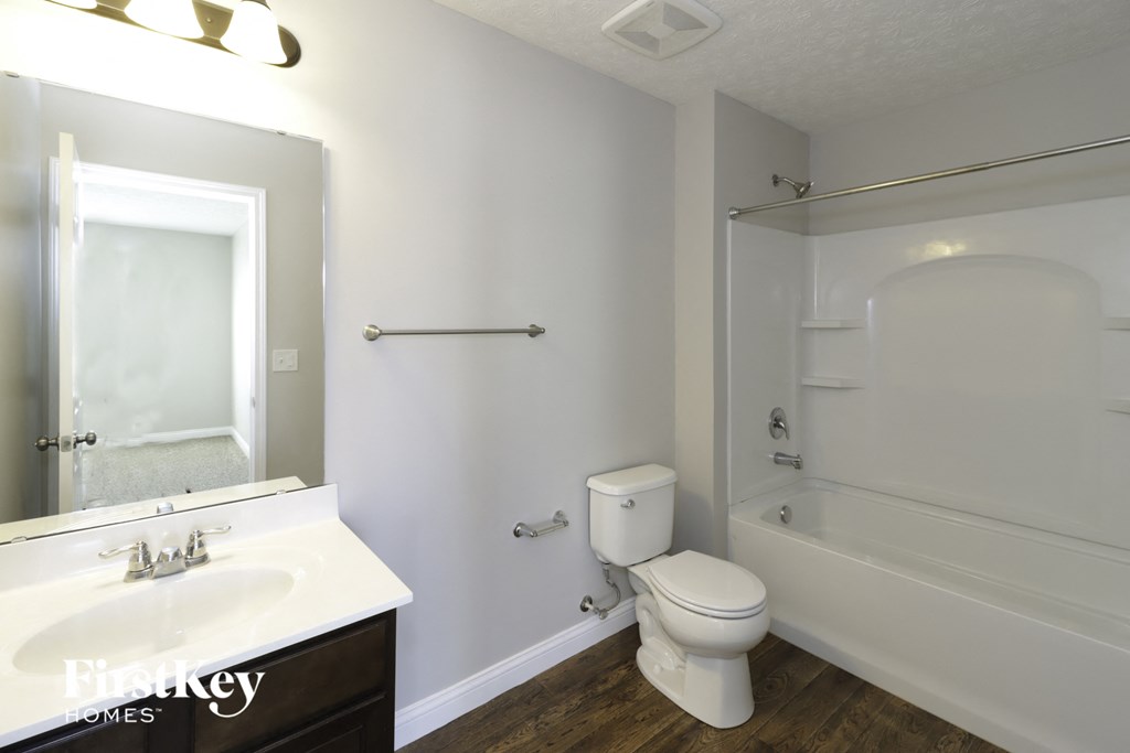 a bathroom with a toilet sink and shower and a mirror