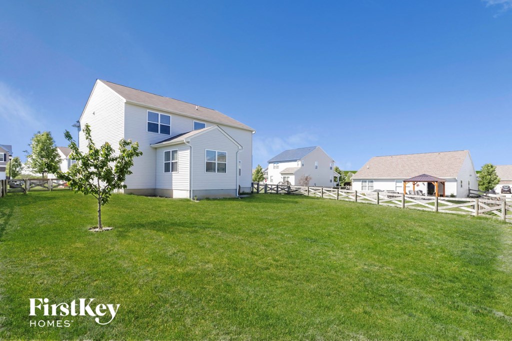a white house with a yard and a white fence
