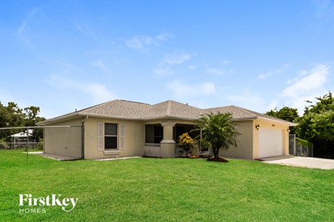 a beige house with a palm tree in the yard
