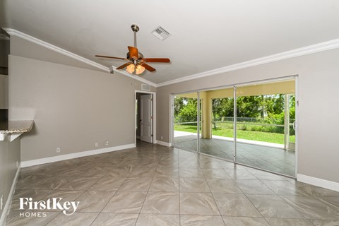 a spacious living room with sliding glass doors to the backyard