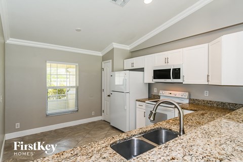 a kitchen with granite counter tops and white appliances