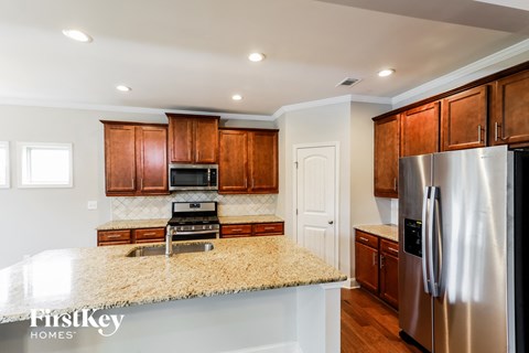 A kitchen with wooden cabinets and a granite countertop.