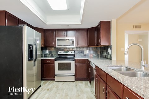 a kitchen with wooden cabinets and granite counter tops and stainless steel appliances