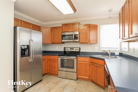 A kitchen with wooden cabinets and a stainless steel refrigerator.