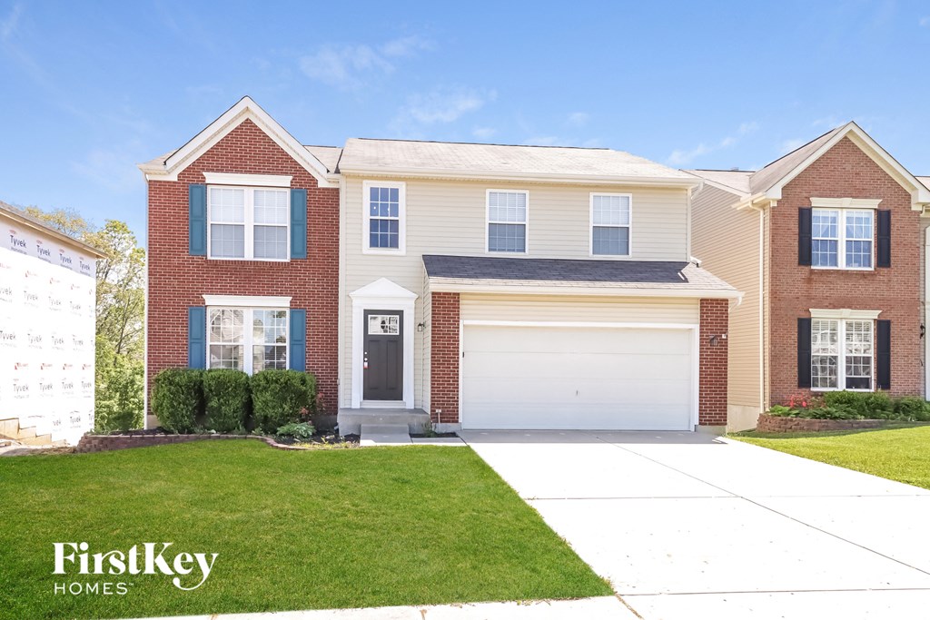 a brick house with a white garage door and a lawn