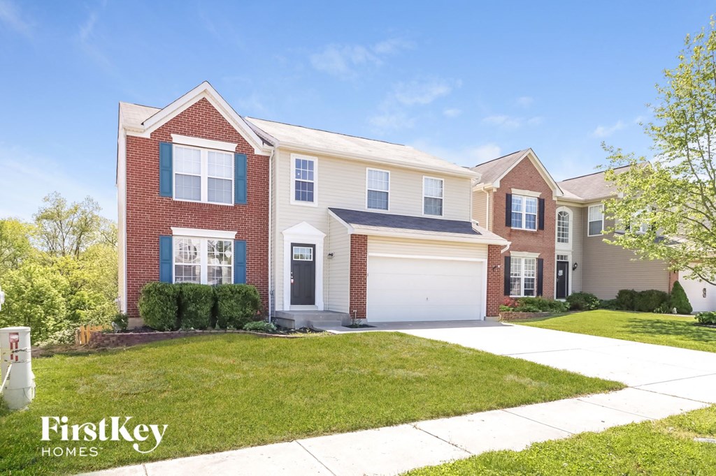 a house with a white garage door in front of a lawn