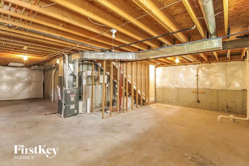 a basement with a staircase and a furnace in it