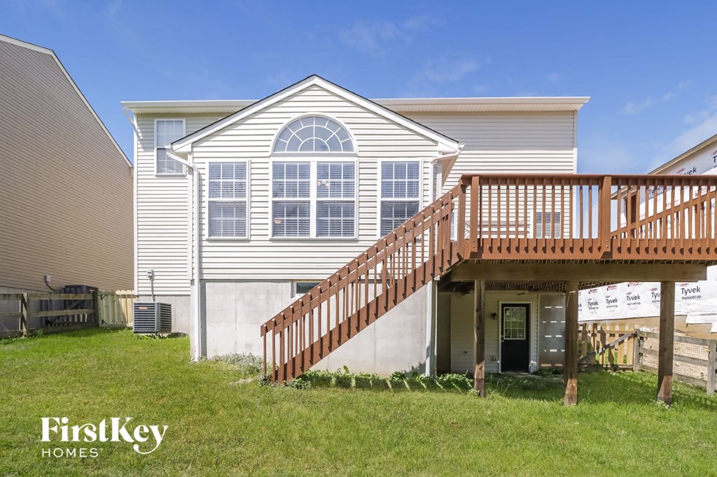 a white house with a deck and a staircase