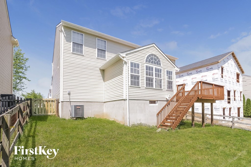 a home with a deck and a staircase in front of a house