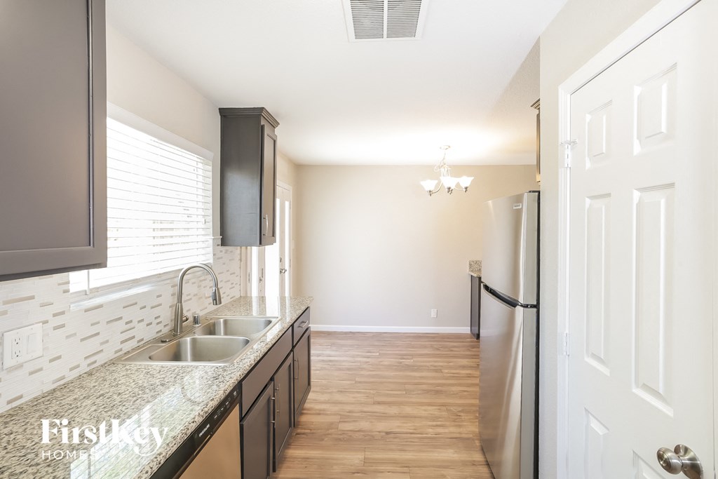 A kitchen with a sink and a refrigerator.