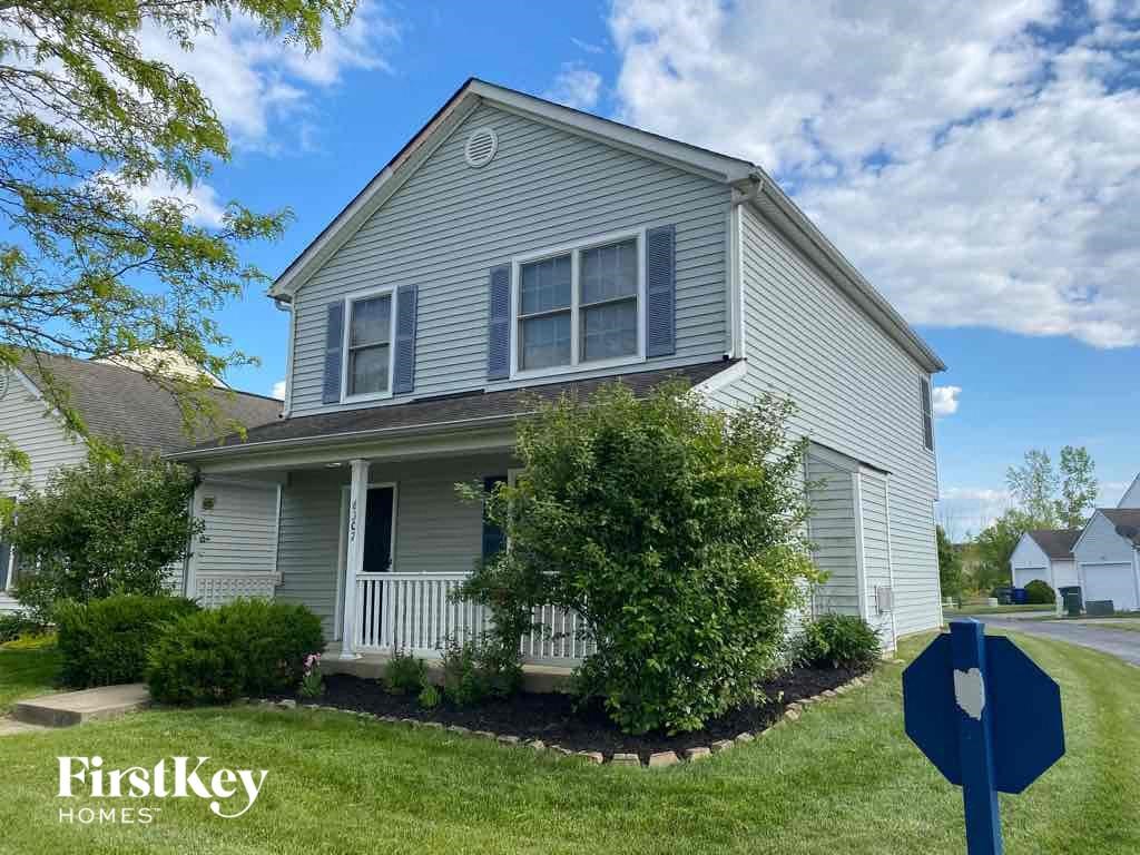 a house with a yard and a street sign in front of it