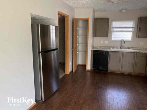 a kitchen with a stainless steel refrigerator and wooden floors