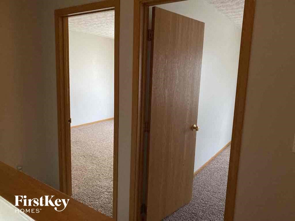an open closet door in a room with a carpeted floor