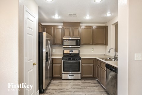 A kitchen with brown cabinets and stainless steel appliances.
