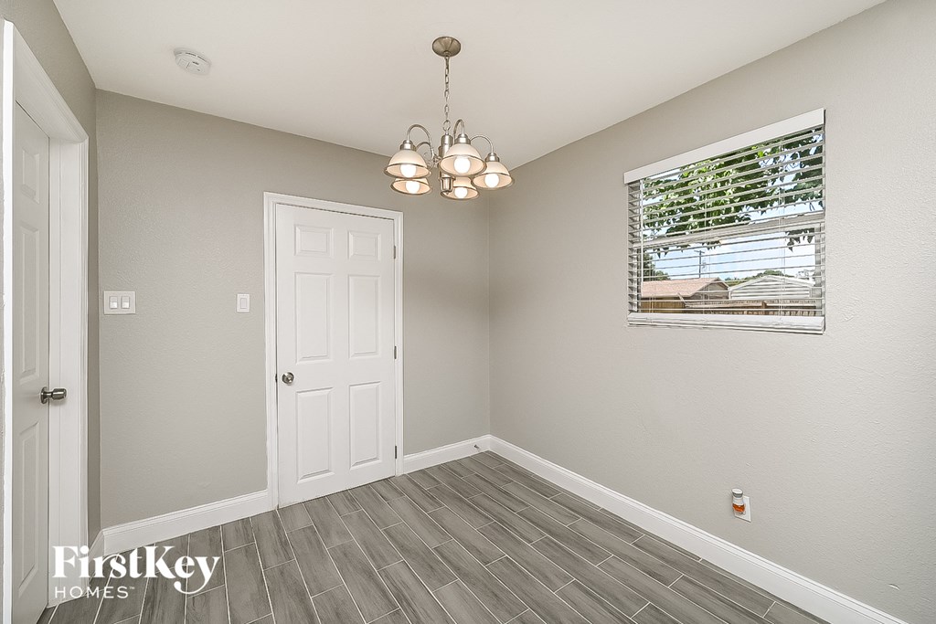 an empty room with a white door and a window