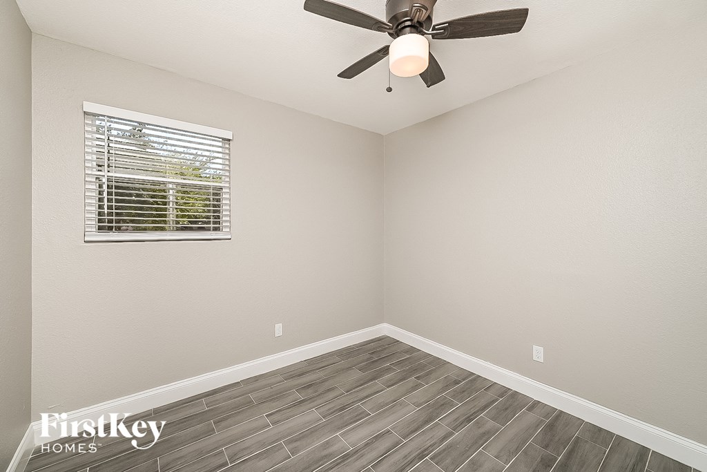 the living room has a ceiling fan and a window