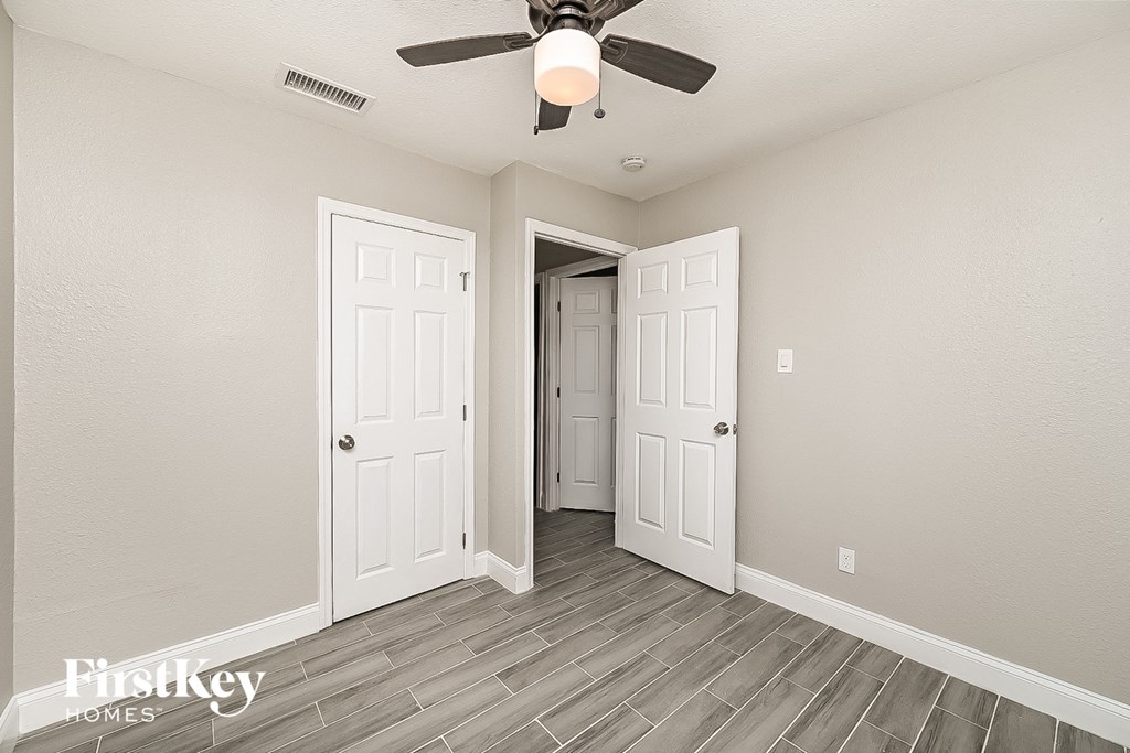 a bedroom with two doors and a ceiling fan
