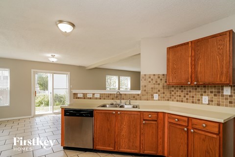 a kitchen with wooden cabinets and a sink and a dishwasher