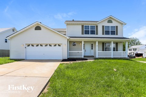 a white house with a white garage door and a lawn