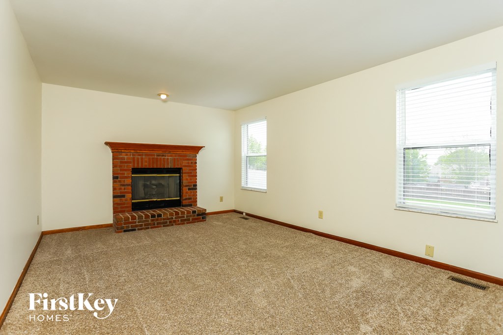the living room of a home with a brick fireplace