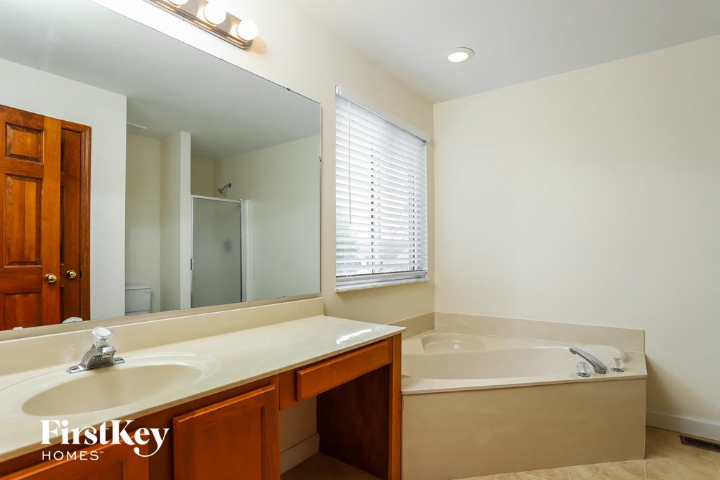 a bathroom with a large mirror and a sink and a tub