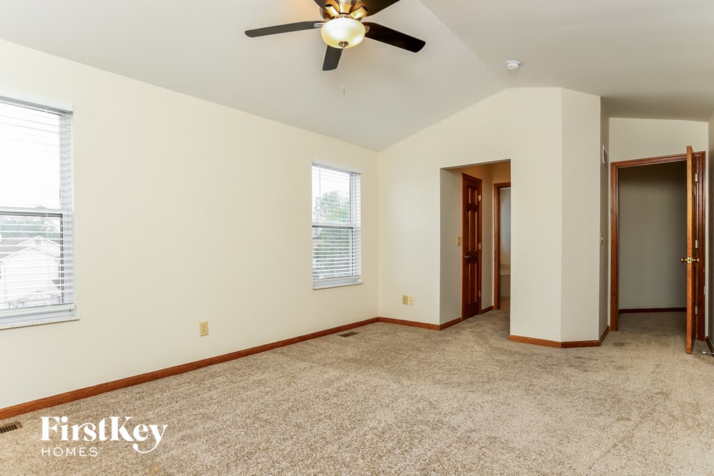 an empty room with a ceiling fan and a door to a closet
