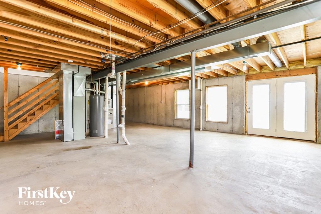 a large basement with unfinished wood ceilings and a staircase
