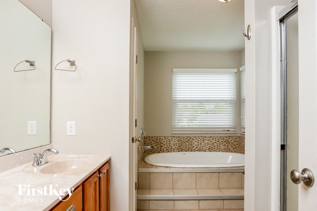 a bathroom with a tub and a sink and a mirror