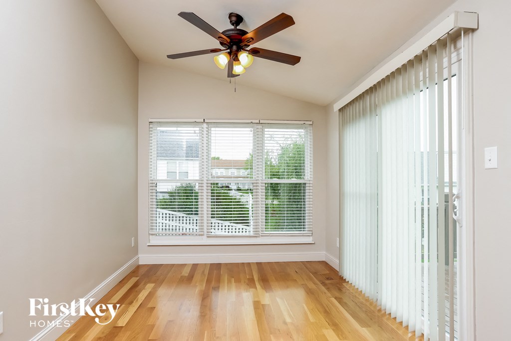 a living room with a large window and a ceiling fan