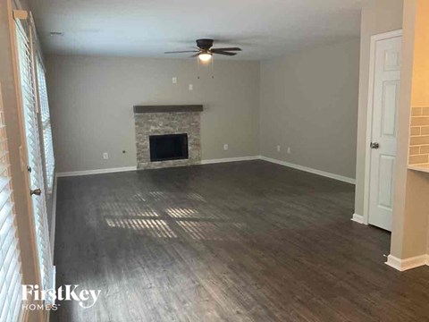 an empty living room with wood floors and a fireplace