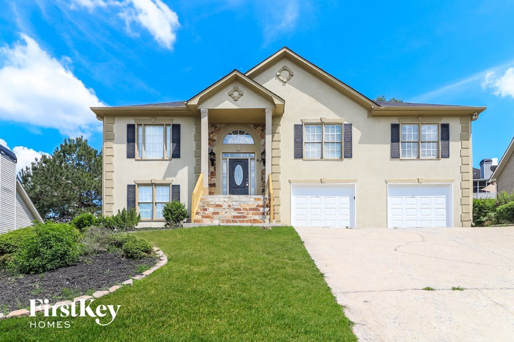 a house with two garage doors and a lawn