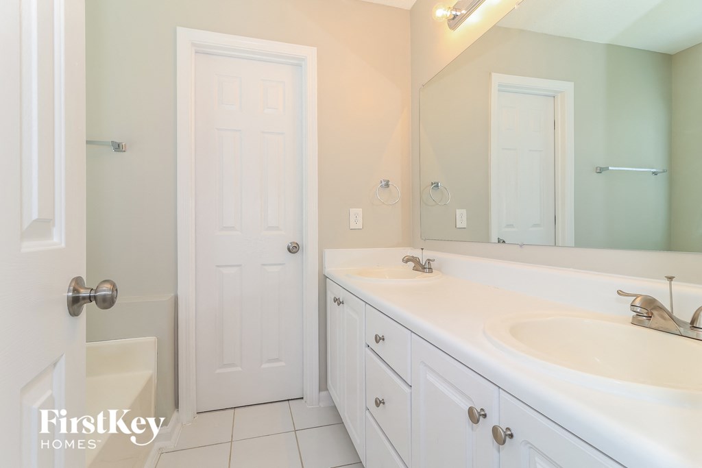 a bathroom with a white sink and a mirror and a shower