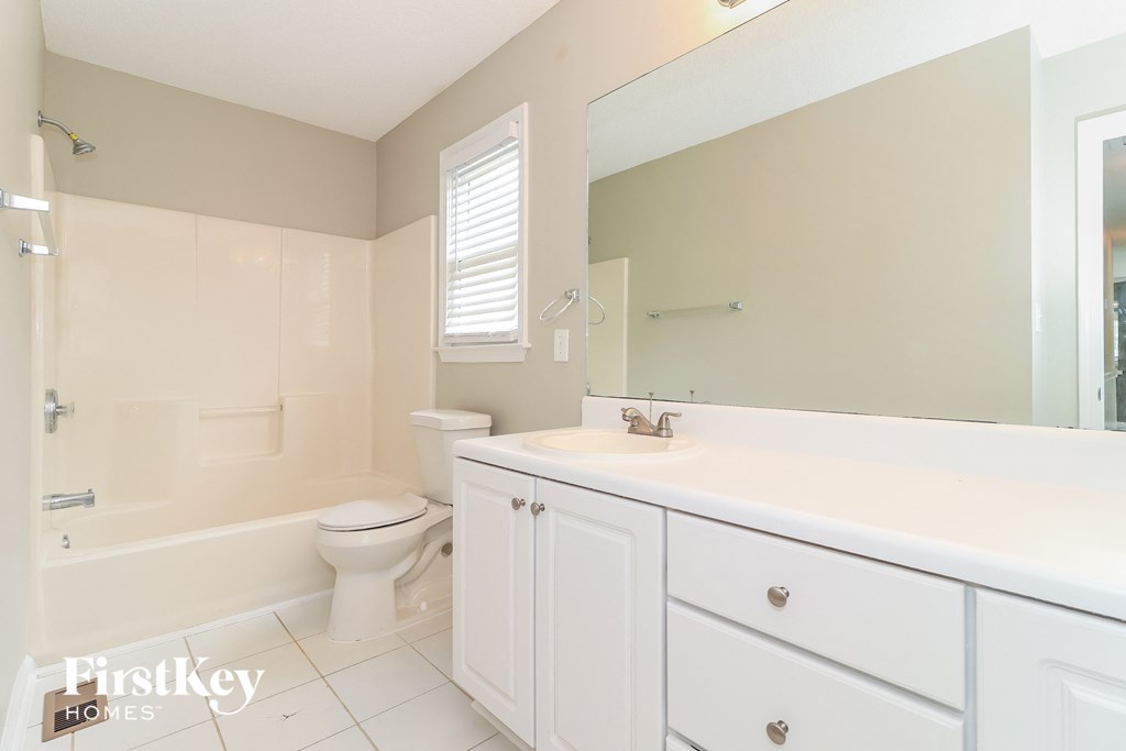 a bathroom with a large mirror and a toilet and a sink