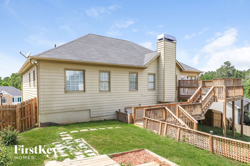 a backyard with a house and a wooden deck